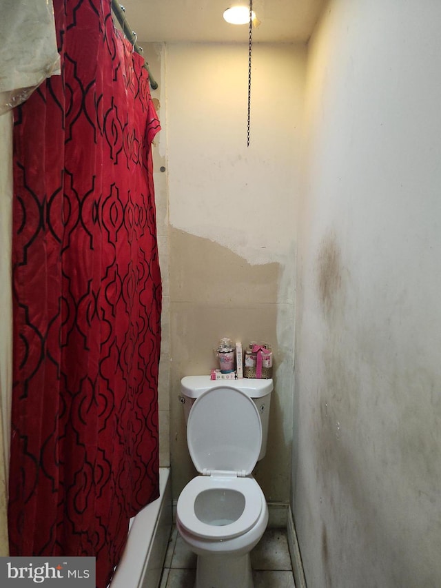 bathroom with tile patterned flooring, toilet, and a shower with curtain