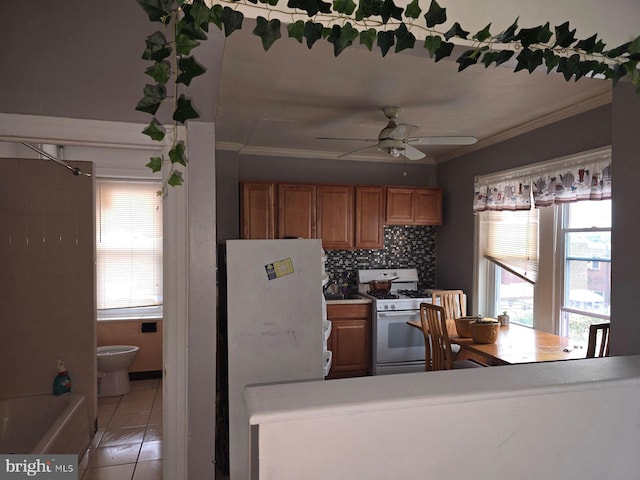 kitchen with ceiling fan, light tile patterned floors, white appliances, tasteful backsplash, and crown molding