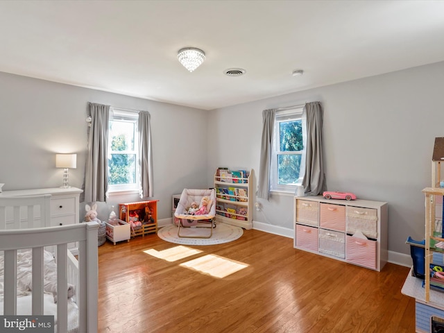 bedroom featuring a nursery area and hardwood / wood-style floors