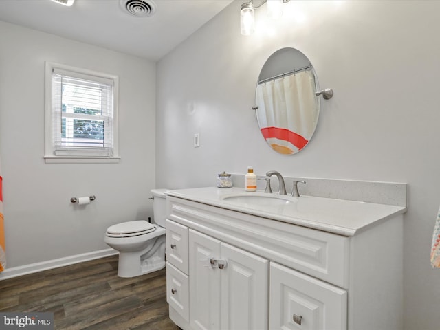 bathroom with toilet, vanity, and wood-type flooring