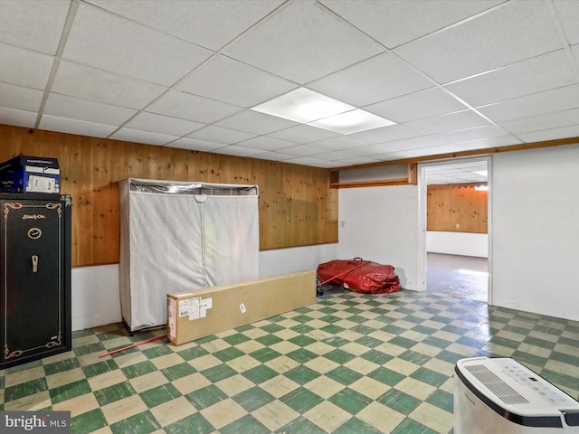 interior space featuring wood walls and a paneled ceiling