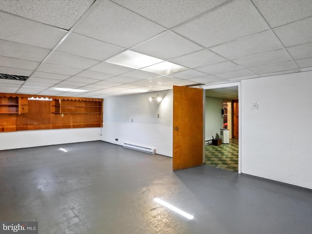 basement with a drop ceiling and a baseboard heating unit