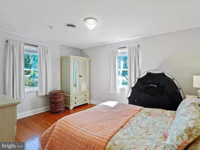 bedroom featuring dark hardwood / wood-style flooring and multiple windows