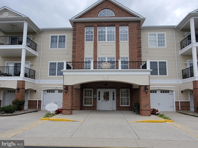 townhome / multi-family property featuring a balcony and a garage