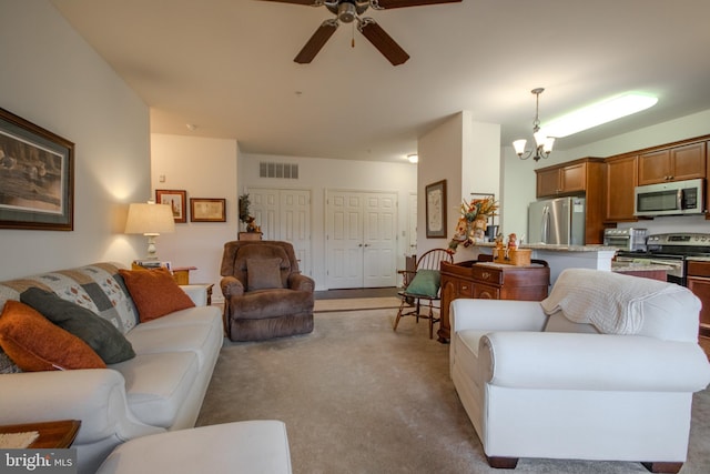 living room featuring light carpet and ceiling fan with notable chandelier