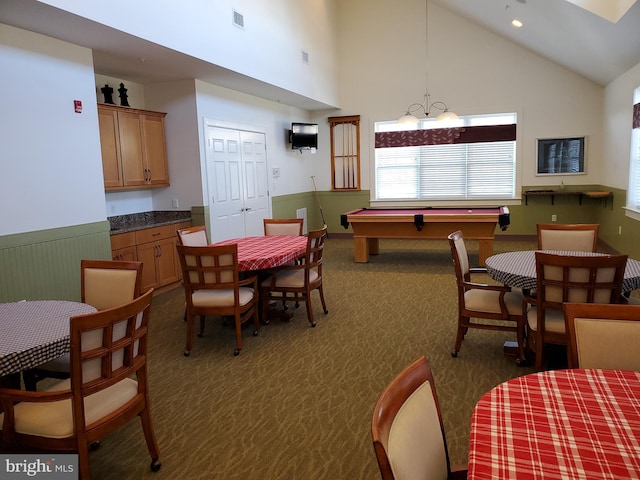 dining space featuring high vaulted ceiling, recessed lighting, a wainscoted wall, visible vents, and dark colored carpet