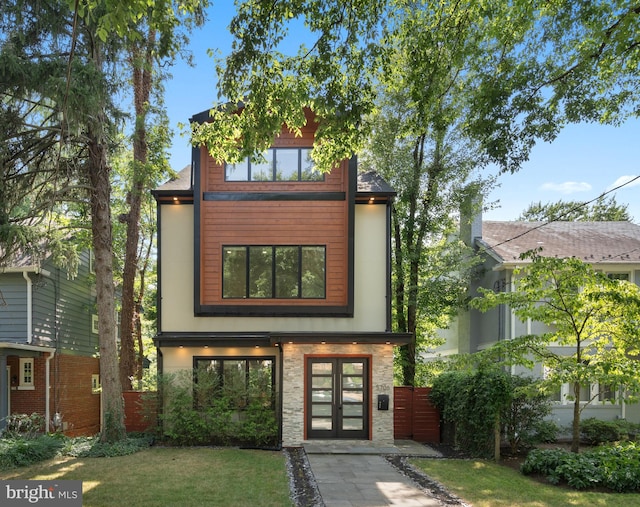 contemporary home with a front yard and french doors