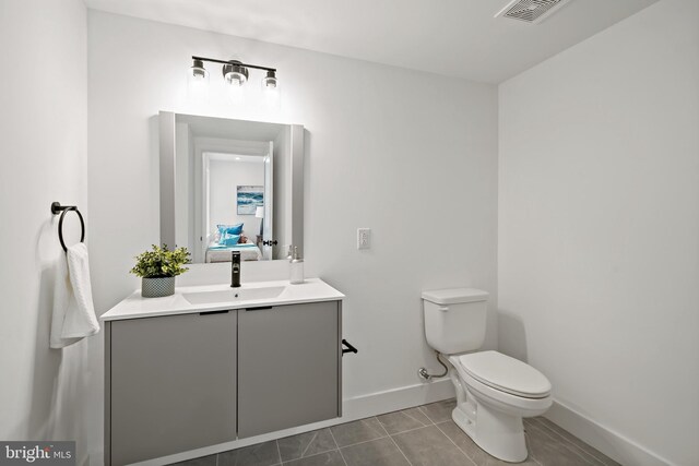 bathroom featuring tile patterned floors, vanity, and toilet