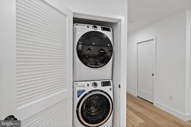 washroom featuring light wood-type flooring and stacked washer / drying machine