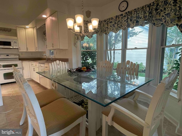 dining area featuring light tile patterned floors, sink, and a chandelier