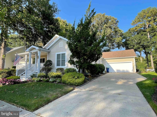 view of front of home with covered porch, a front yard, and a garage