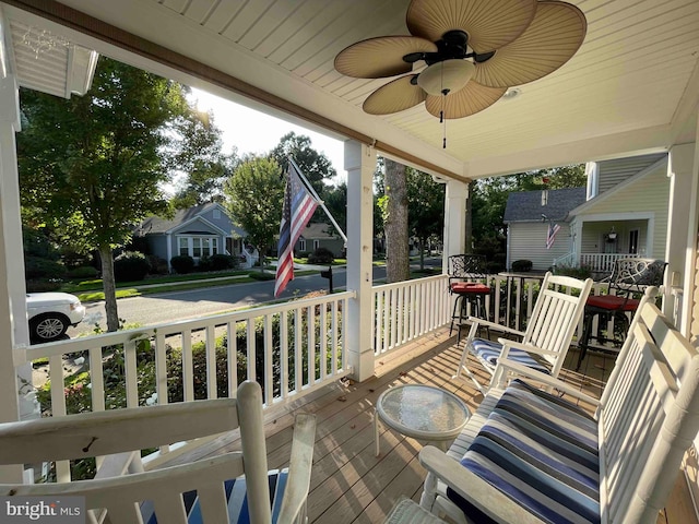 wooden terrace with ceiling fan and covered porch