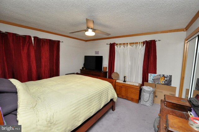 carpeted bedroom featuring ornamental molding, a textured ceiling, and ceiling fan