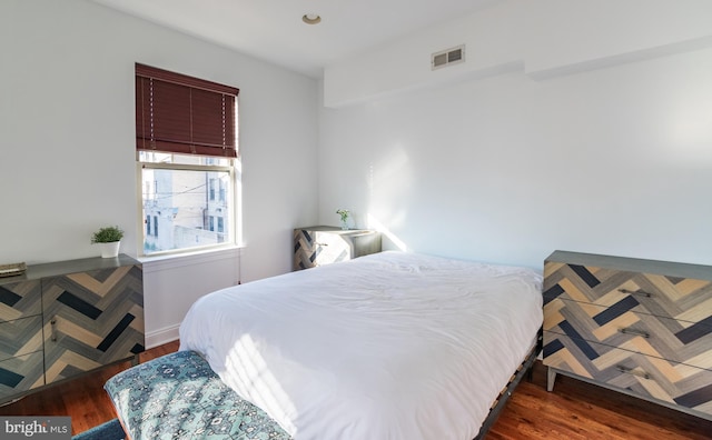 bedroom with dark hardwood / wood-style flooring