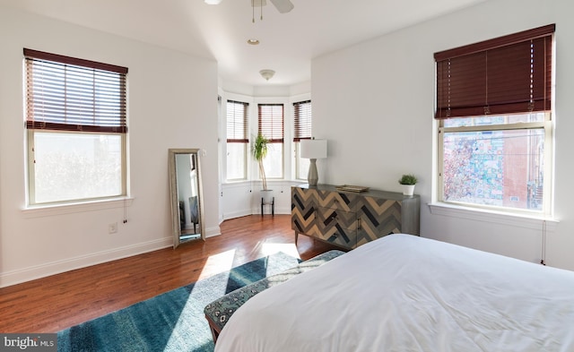 bedroom with ceiling fan, hardwood / wood-style flooring, and multiple windows