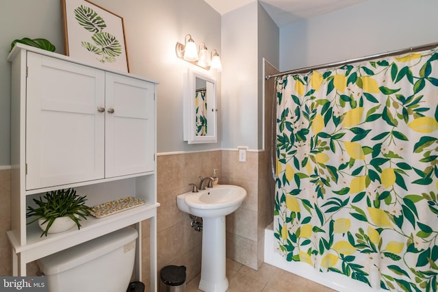 full bathroom with tile walls, tile patterned flooring, shower / tub combo with curtain, and toilet