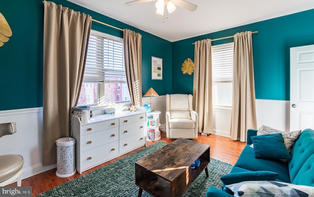 living room featuring wood-type flooring and ceiling fan