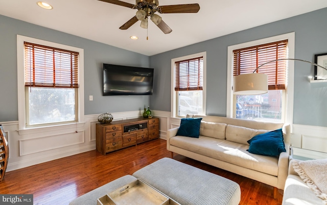 living room featuring a wealth of natural light, ceiling fan, and dark hardwood / wood-style flooring