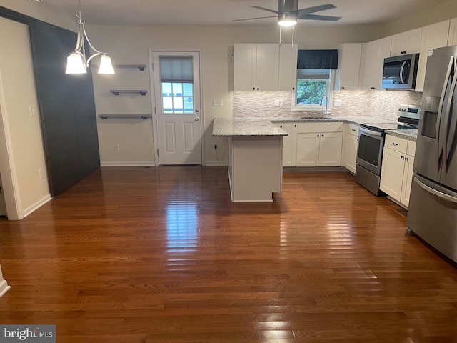 kitchen featuring ceiling fan with notable chandelier, white cabinets, appliances with stainless steel finishes, and dark hardwood / wood-style floors