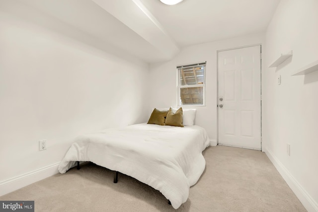 bedroom with light carpet and vaulted ceiling