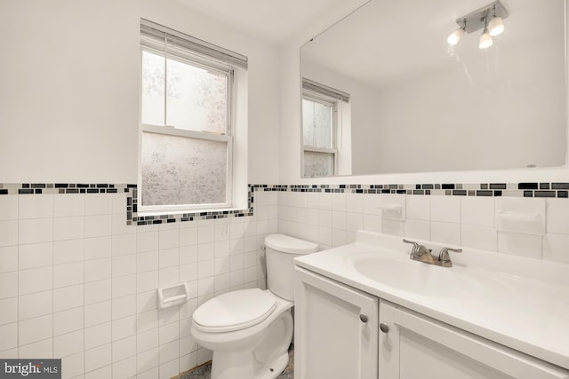 bathroom with tile walls, vanity, and toilet