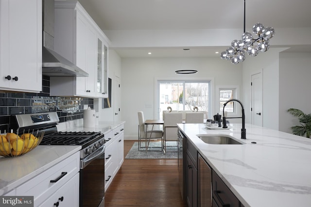 kitchen featuring appliances with stainless steel finishes, white cabinetry, hanging light fixtures, and sink