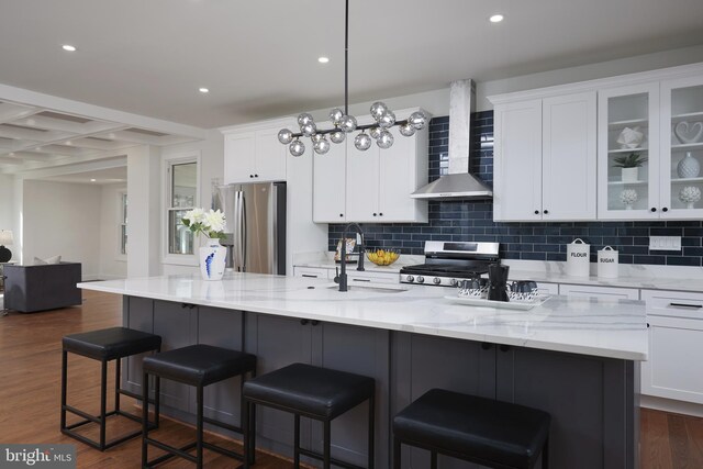 kitchen with white cabinets, dark wood-type flooring, wall chimney range hood, and appliances with stainless steel finishes