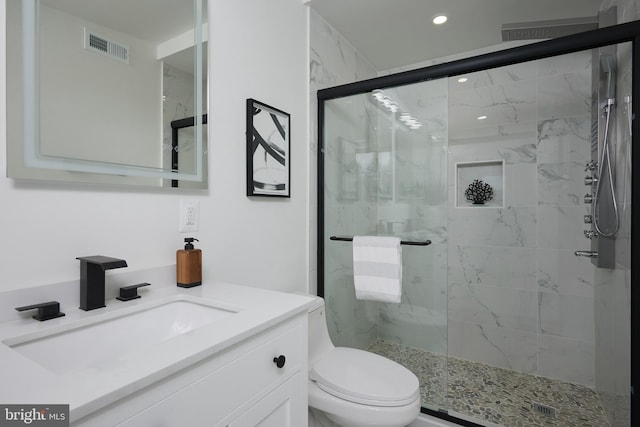 bathroom with vanity, toilet, and an enclosed shower