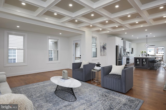 living room featuring beamed ceiling, dark hardwood / wood-style flooring, sink, and coffered ceiling