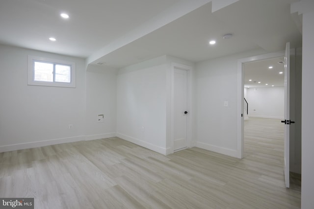 basement with light hardwood / wood-style flooring