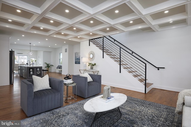 living room with beam ceiling, dark hardwood / wood-style floors, coffered ceiling, and a notable chandelier