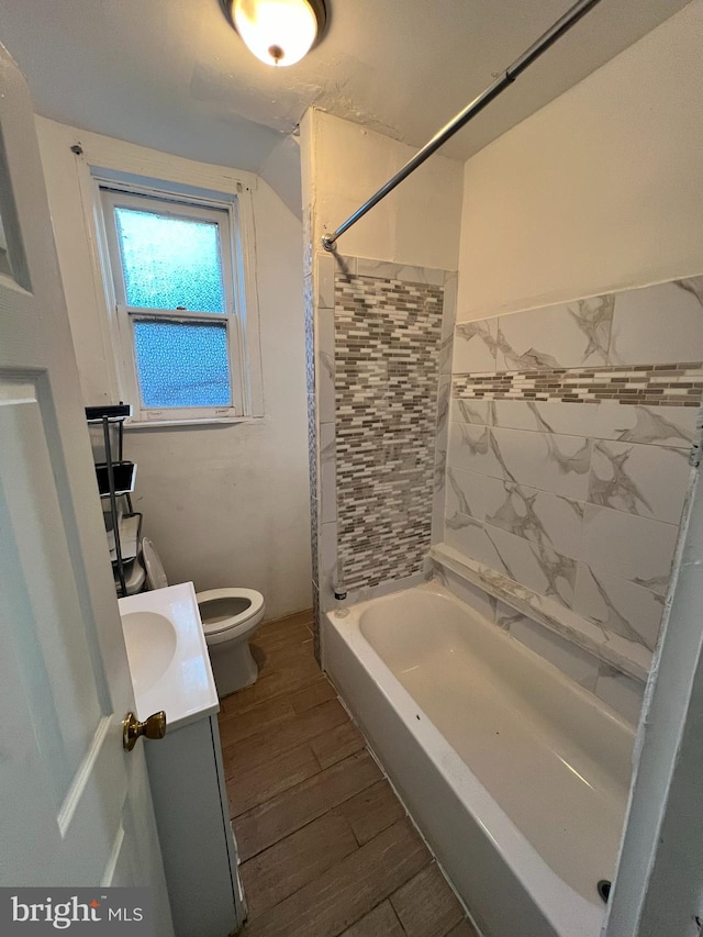 full bathroom with vanity, tiled shower / bath combo, toilet, and hardwood / wood-style flooring