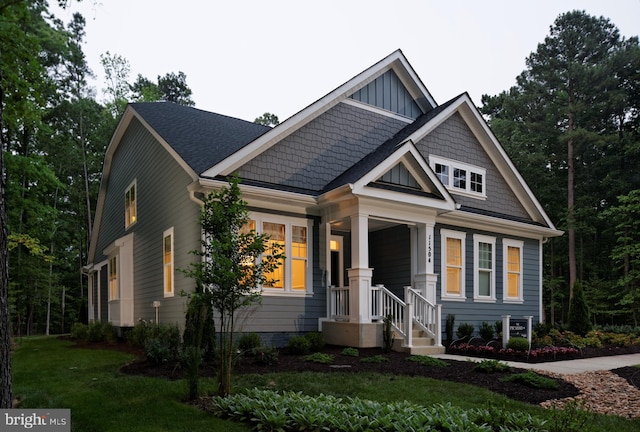 craftsman-style home featuring a porch and a front yard