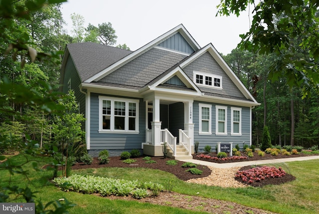 craftsman-style house featuring a porch and a front yard