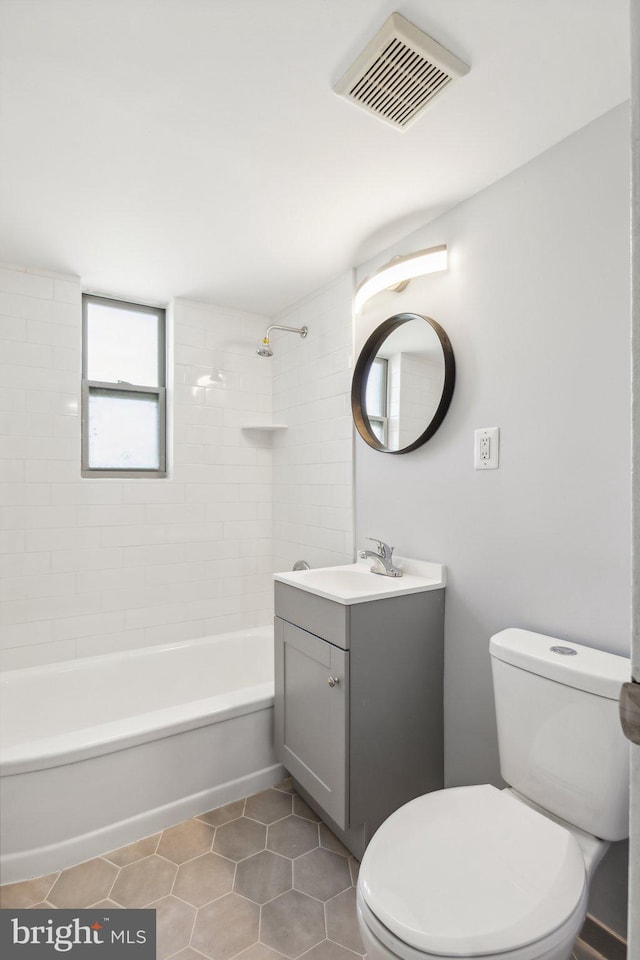 full bathroom featuring vanity, toilet, tile patterned floors, and tiled shower / bath