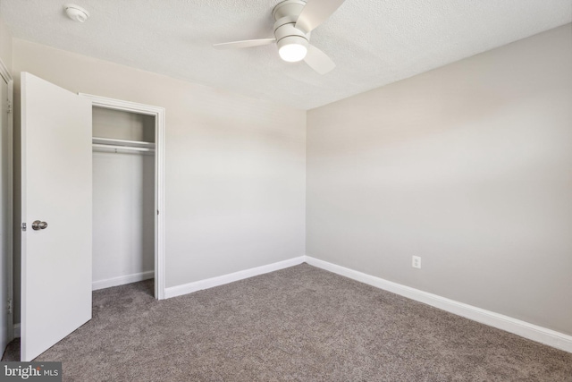 unfurnished bedroom featuring carpet, a textured ceiling, a closet, and ceiling fan