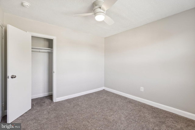 unfurnished bedroom featuring carpet flooring, a closet, a ceiling fan, baseboards, and a textured ceiling
