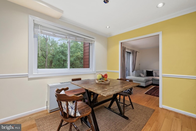 dining space featuring light hardwood / wood-style flooring and crown molding