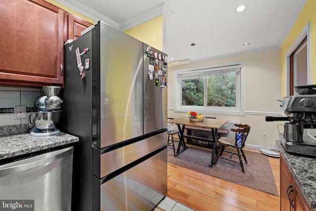 kitchen with ornamental molding, stone countertops, light hardwood / wood-style flooring, and stainless steel appliances