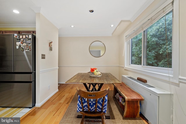 dining space featuring light wood-type flooring and ornamental molding