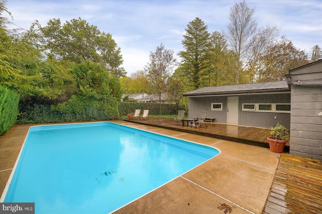 view of pool with a wooden deck and a patio