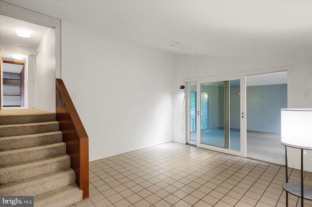 interior space with vaulted ceiling and light tile patterned floors