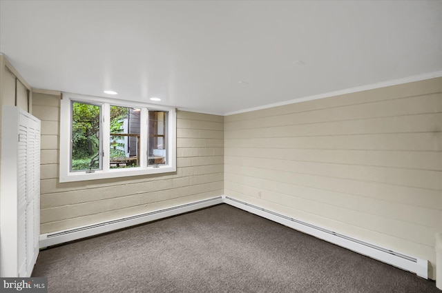 empty room with crown molding, dark colored carpet, and a baseboard radiator