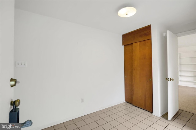 unfurnished bedroom with light tile patterned floors and a closet