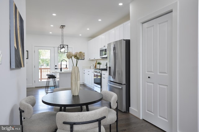 dining area with sink and dark wood-type flooring