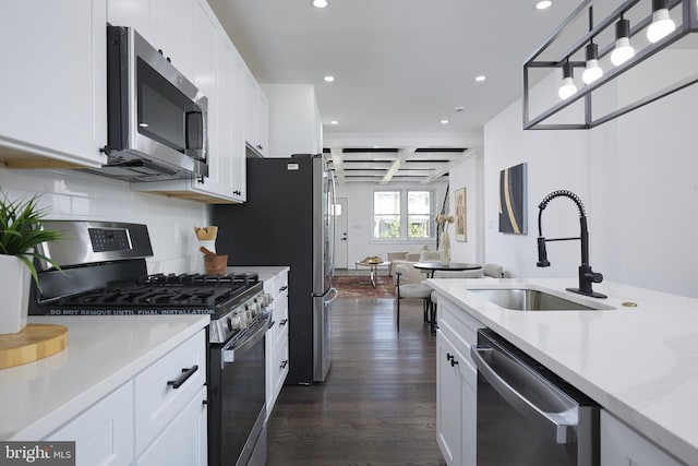 kitchen featuring appliances with stainless steel finishes, dark hardwood / wood-style flooring, beamed ceiling, and white cabinets