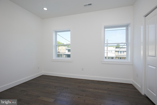 spare room featuring dark hardwood / wood-style flooring and plenty of natural light