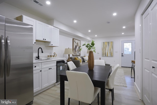 dining space with light hardwood / wood-style flooring and sink