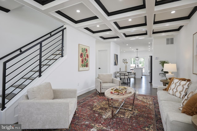 living room with coffered ceiling, beam ceiling, and dark wood-type flooring