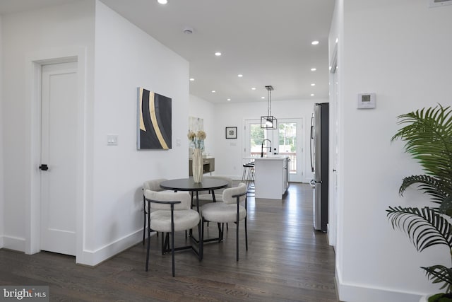 dining space featuring sink and dark wood-type flooring